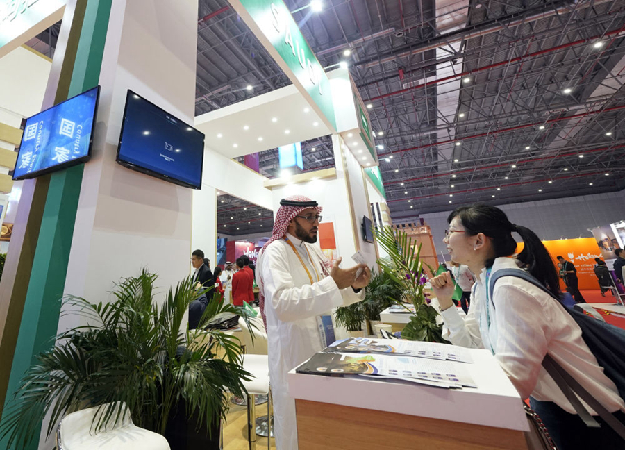 2018年11月6日，在上海举行的首届中国国际进口博览会上，参观者与沙特阿拉伯展区的工作人员交流。