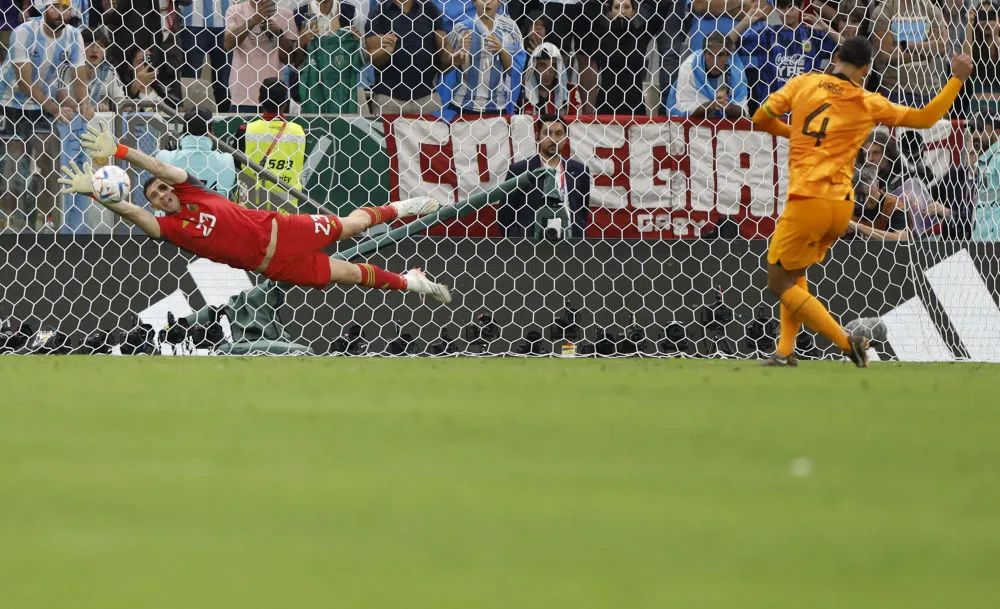 阿根廷队守门员马丁内斯(左)在点球大战中扑出荷兰队球员范戴克的