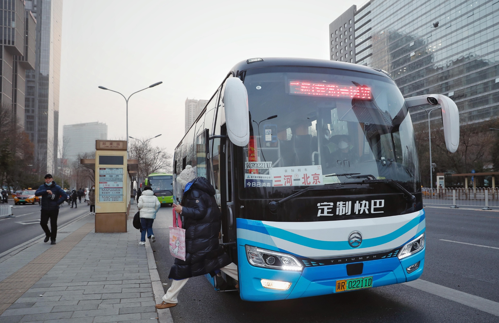 2022年12月12日,北京郎家园公交站台,乘客正在下车