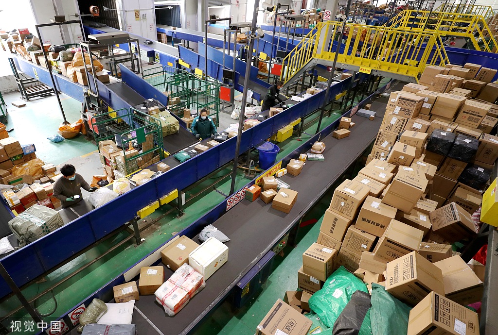 东营区胜园街道的中国邮政东营市邮件处理中心,员工在分拣快递包裹