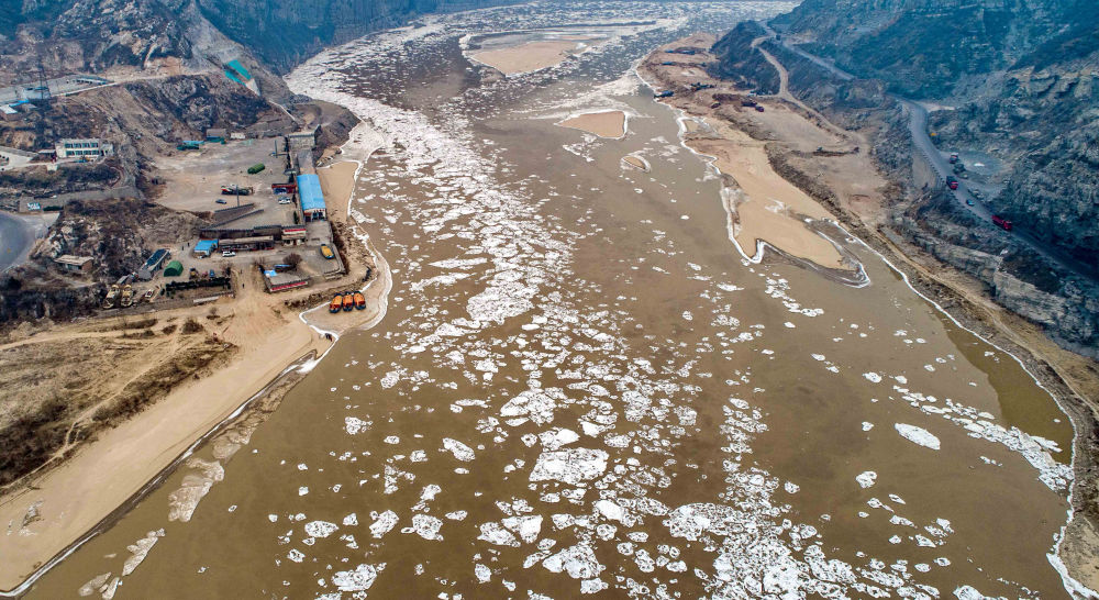 在黄河山西河津禹门口河段,流凌像花朵一样点缀在河面上.