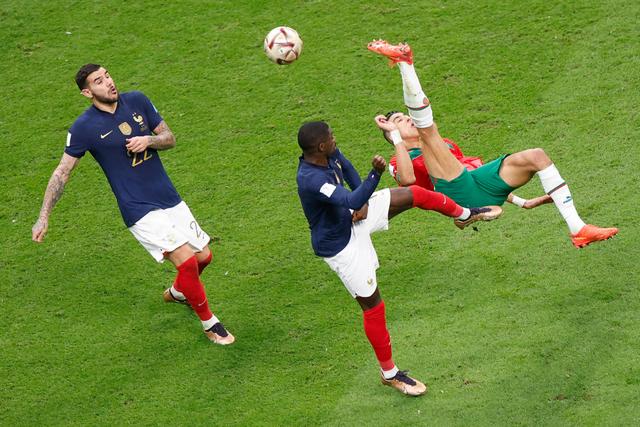 12月14日,摩洛哥队球员亚米克(右)在比赛中倒钩射门.