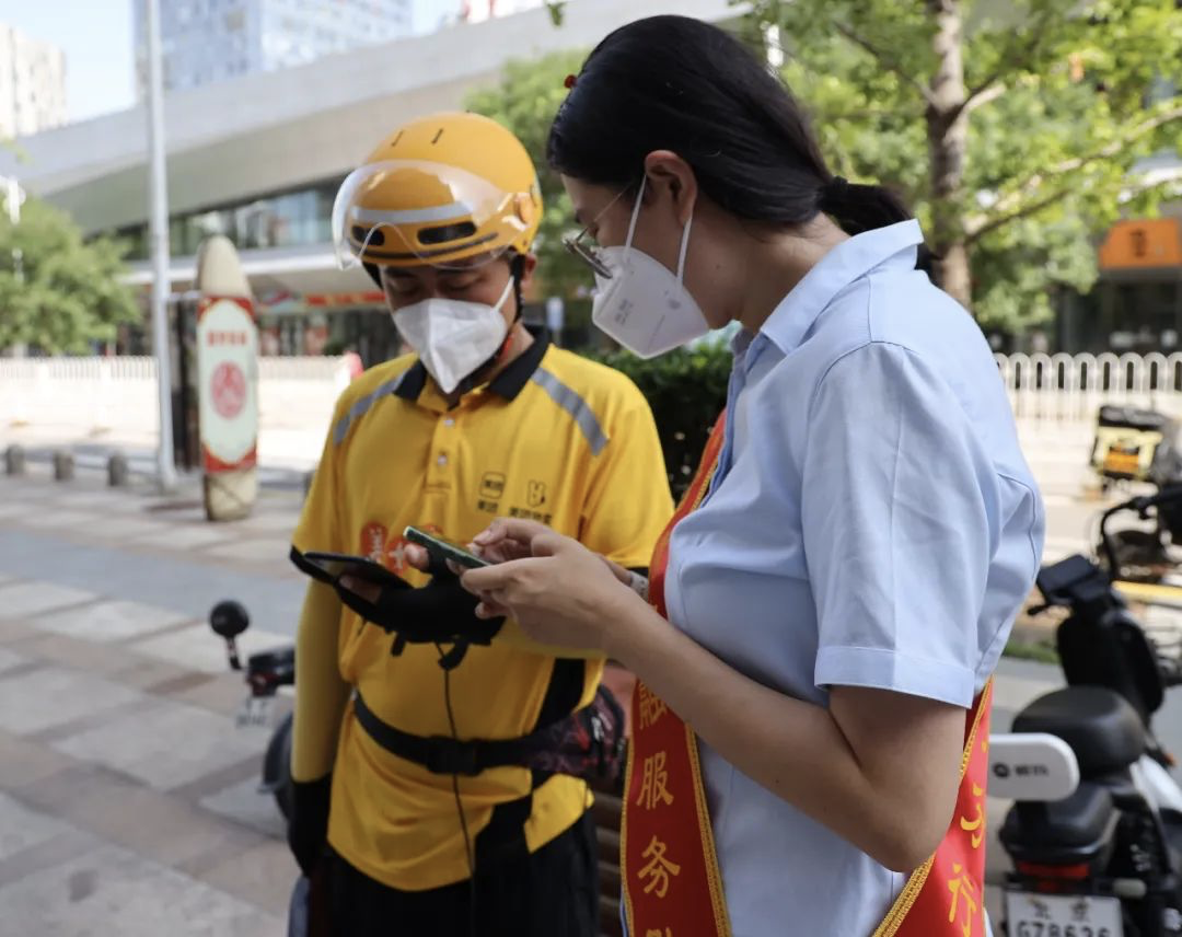 建行北京通州分行志愿者指导外卖小哥领取“安疫保”