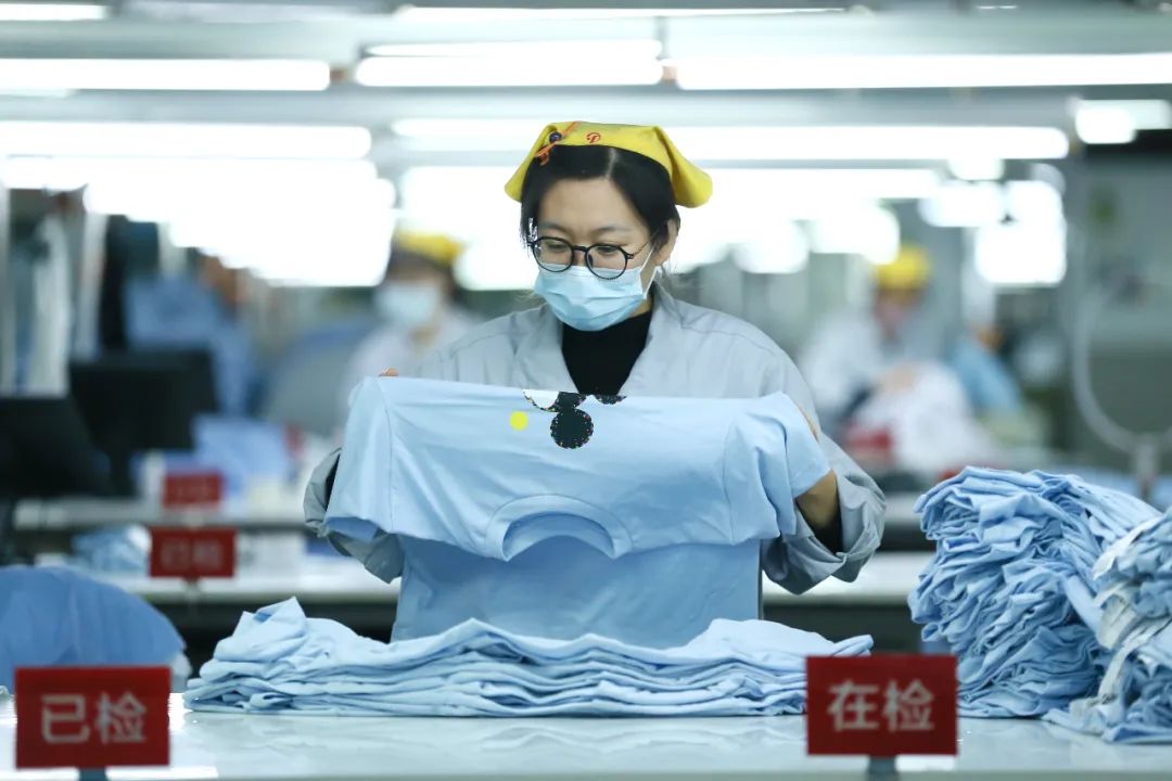 2022年12月16日,山东青岛一家服装企业的工人在检验准备出口到海外