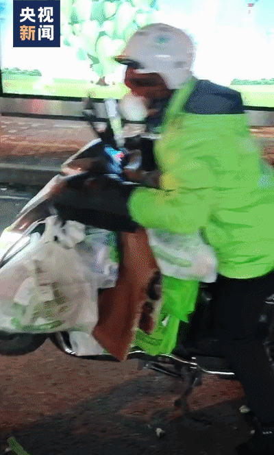 △16日晚，一名騎手騎著裝滿物資的電動車，在同事協助下出發了。