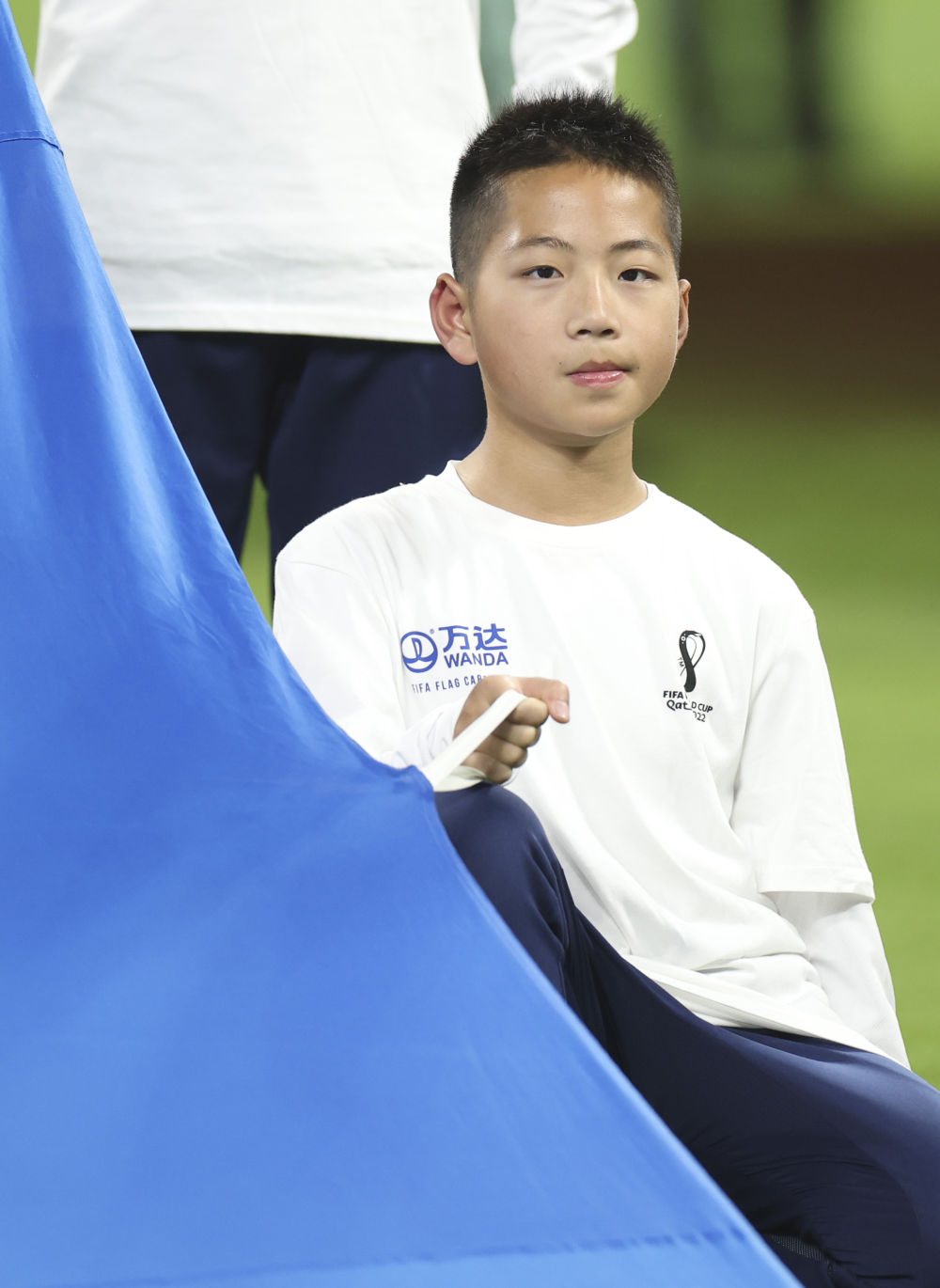 12月17日，来自中国的小旗手金粲璨在比赛前展示国际足联旗帜。新华社记者 贾浩成 摄