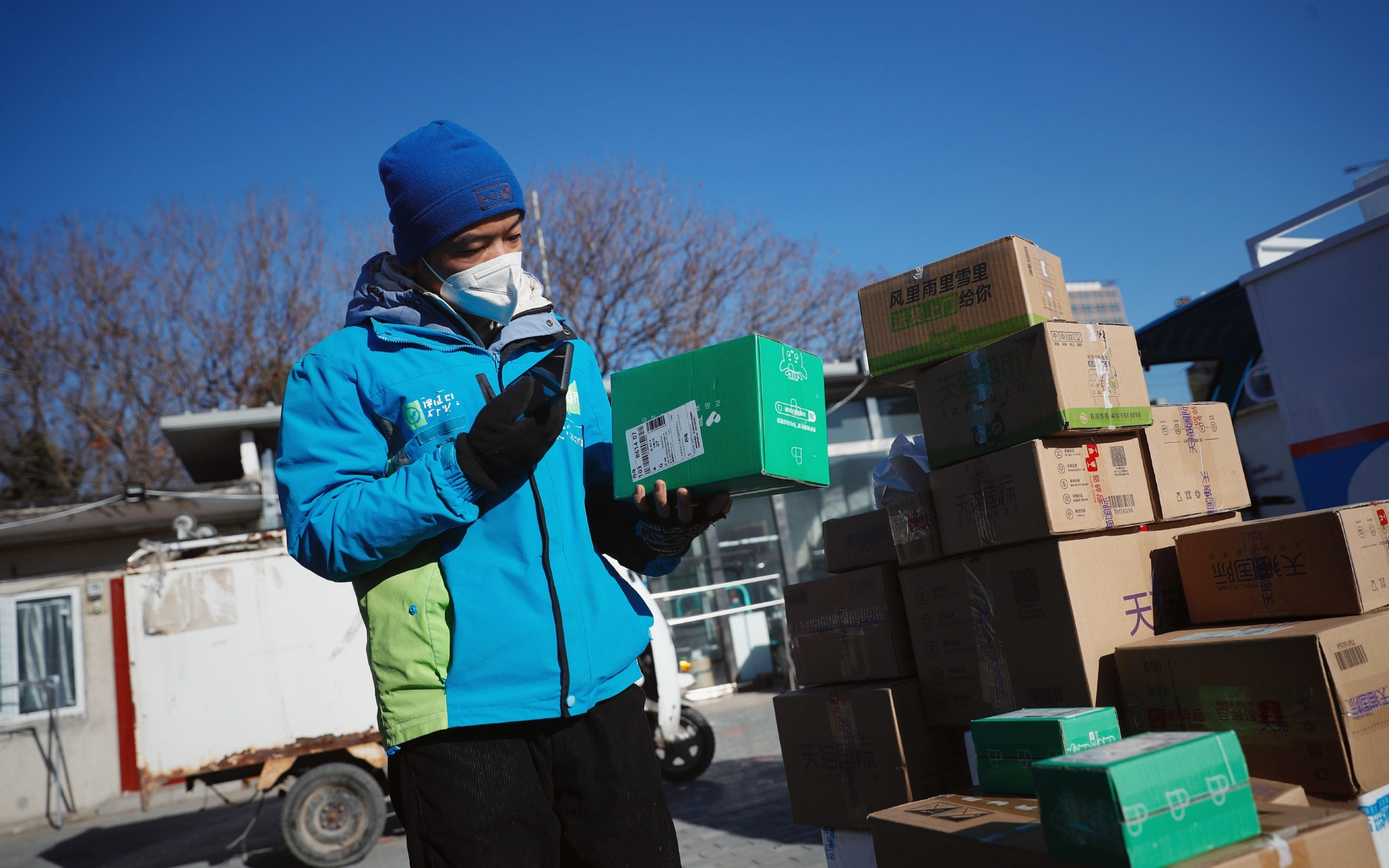 菜鸟物流丹鸟朝阳区黄渠站,一位快递员正在分拣阿里健康绿色包装箱