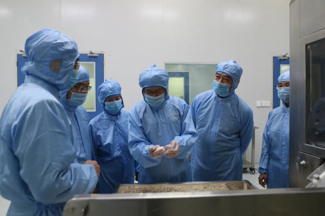 刘红宁团队在生产车间研究中药片剂 （中间为刘红宁）。
