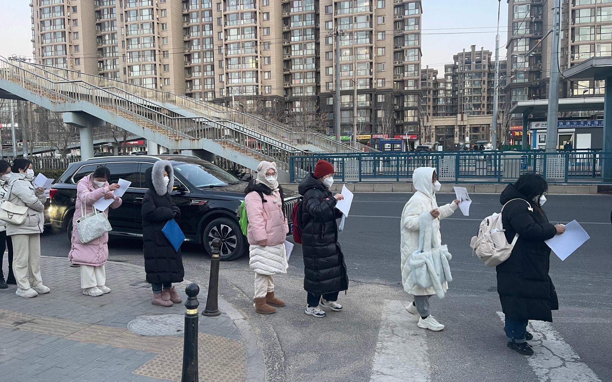 在校门外，考生自觉排起队伍等待查验证件。 新京报记者 刘洋 摄