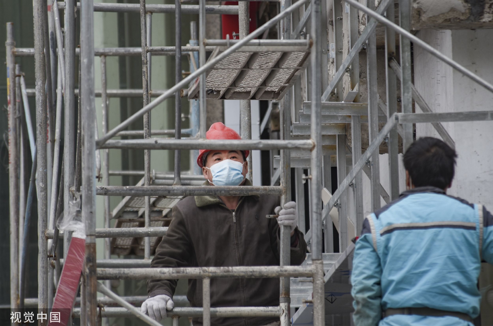 2022年12月26日,浙江金华一些工地上,施工人员戴着口罩进行施工作业