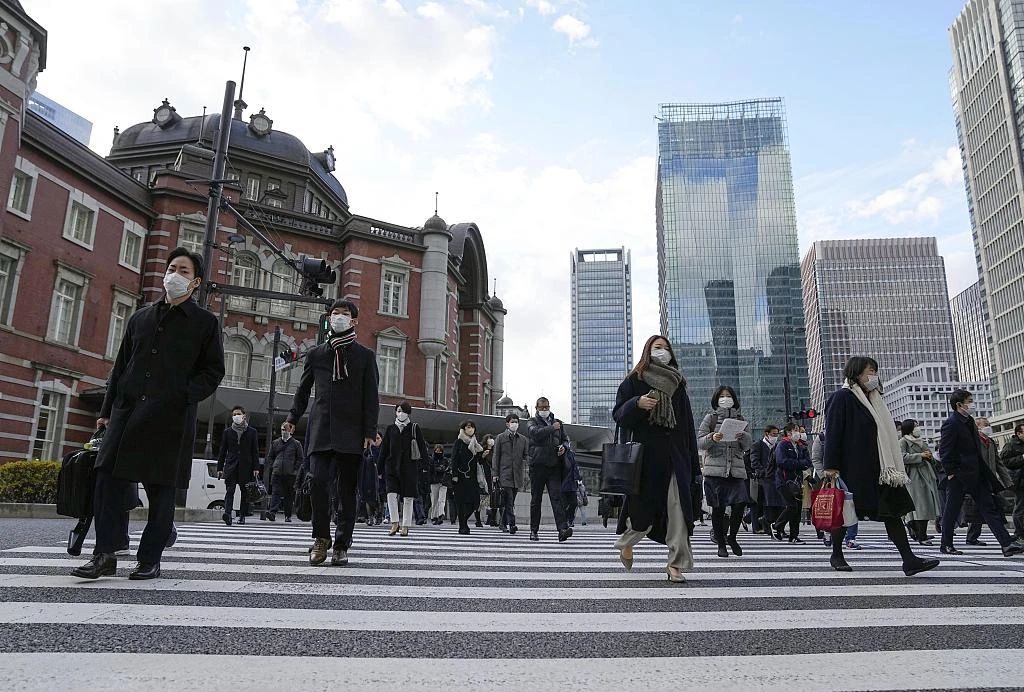 当地时辰2022年12月28日,日本东京站前,戴着口罩上班的上班族在2022年的终末一个使命日上班。图/视觉中国