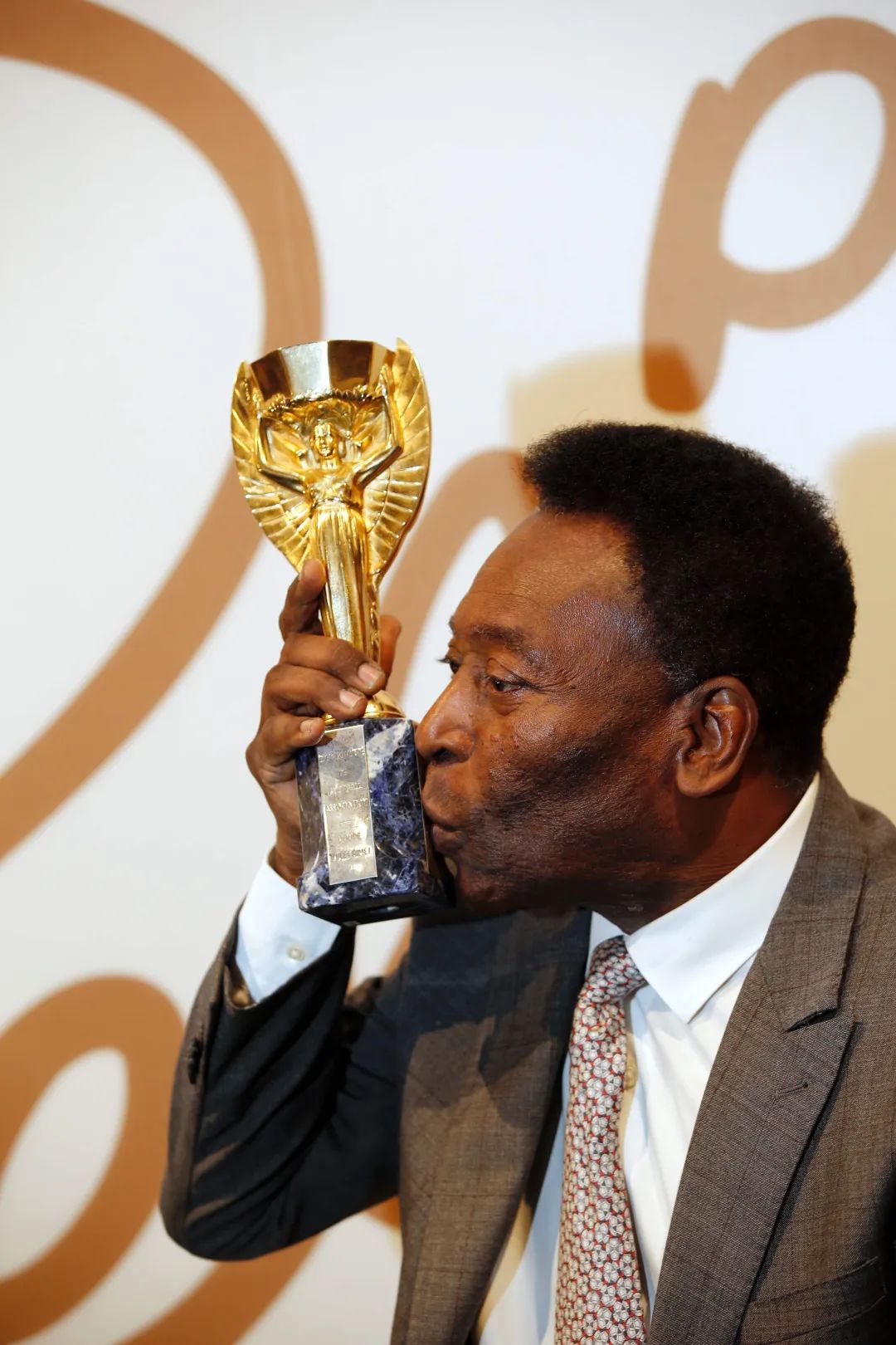 图为2016年6月1日,"球王"贝利在伦敦举行的拍卖会上亲吻"雷米特杯"