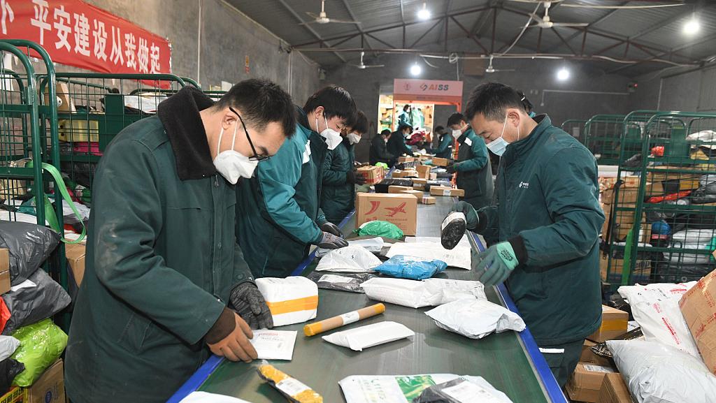 2023年1月1日,石家庄,在中国邮政集团公司河北新乐市分公司分拣车间,工作人员在分拣快递。视觉中国 图