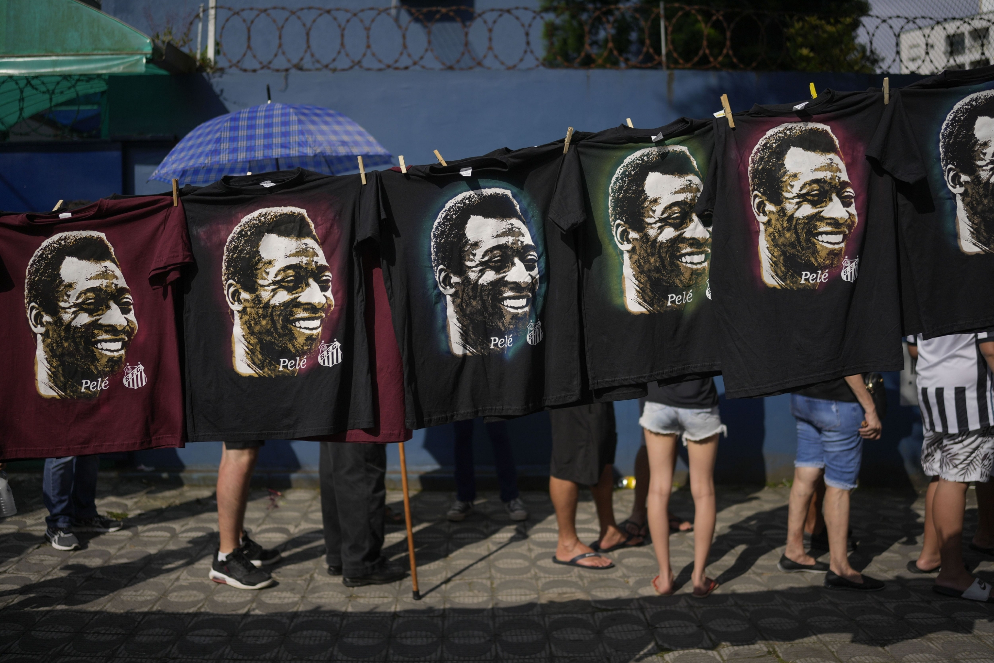2023年1月2日，巴西桑托斯，人们排队处，印有贝利的T恤正在展示出售。