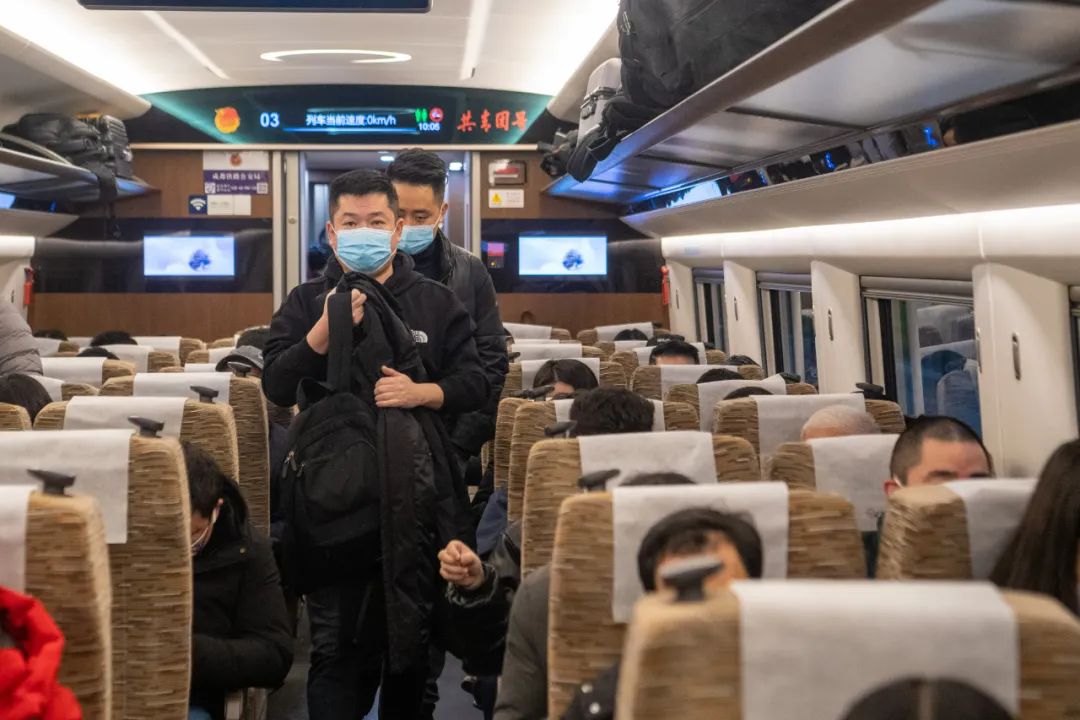 发车的g8612次成渝城际高铁"复兴号"智能动车组车厢内,乘客准备入座