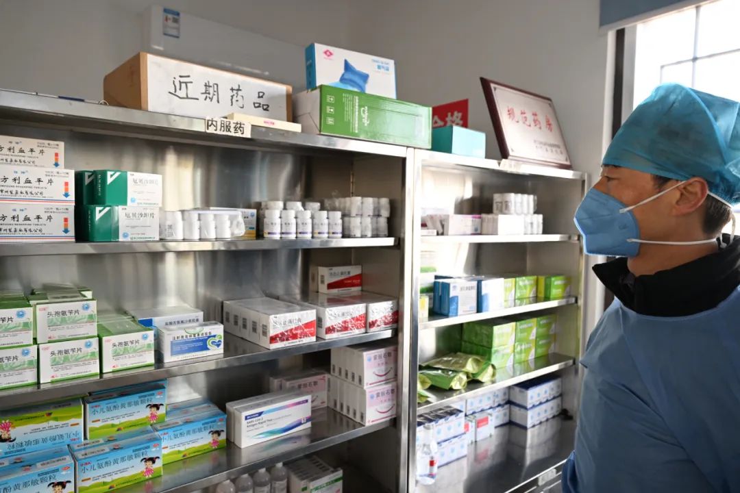1月7日,在庐江县万山镇长冲村卫生室,医生正在药房配药.