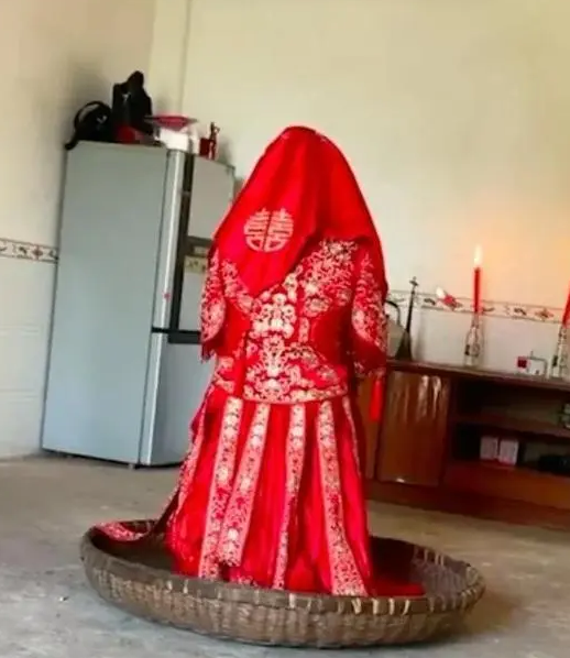 ▲视频中，一位新娘在簸箕中独坐了5小时。截图来自社交媒体视频