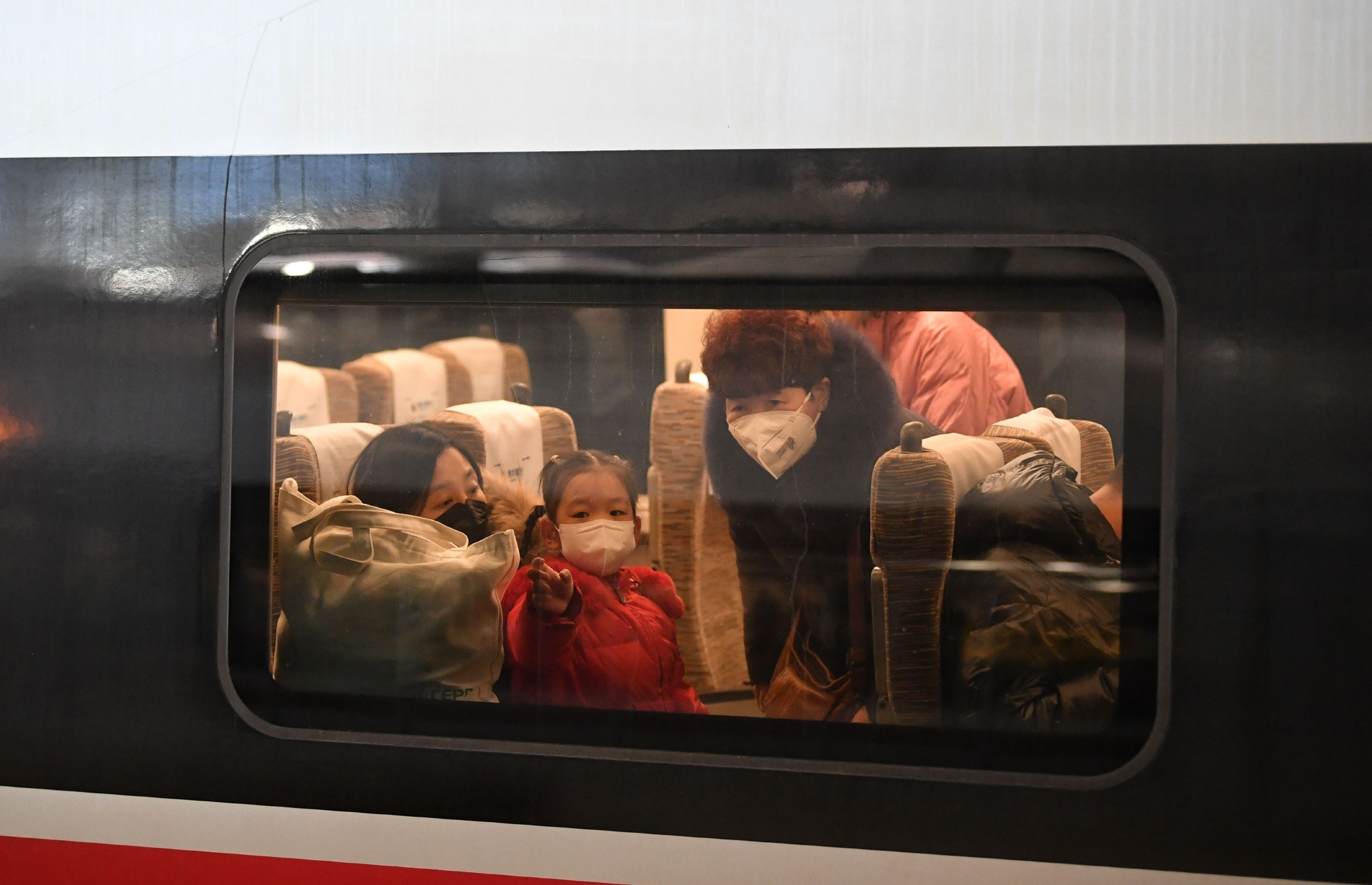 戴着口罩的小女孩望向车窗外.新京报记者 王贵彬 摄