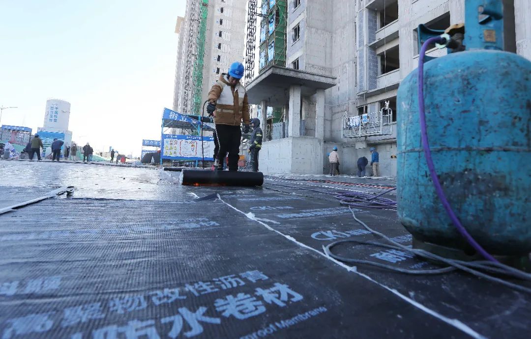 工人正在为地库顶板铺设防水保护层.保定日报记者 翟志刚 摄