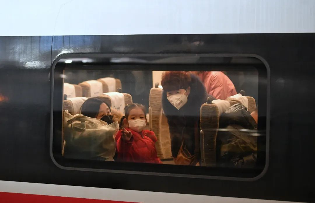 2023年1月8日,北京南站的列车车厢里,旅客佩戴着口罩望向窗外.