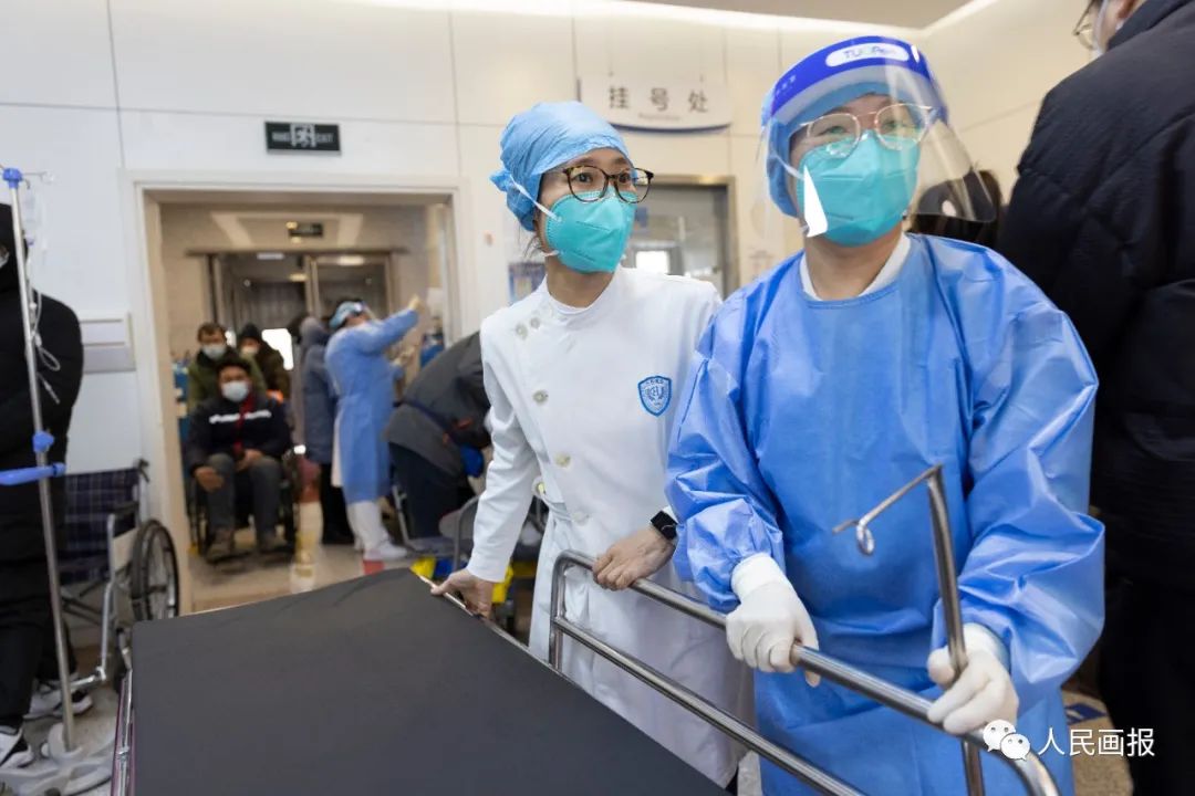 北京大学人民医院急诊科，护士长周颖（左）带领护士推行平板车，准备接收急救车新送来的患者。