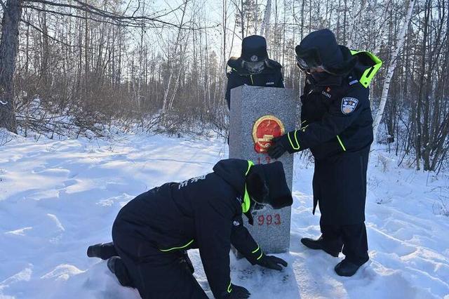 北极边境派出所的移民管理警察巡逻途中擦拭界碑.邱小平/摄