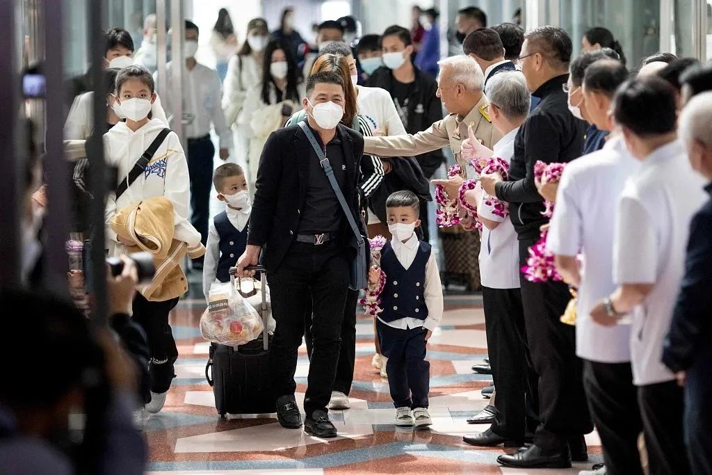 当地时间2023年1月9日,泰国曼谷,泰国官员向抵达素万那普国际机场的中国游客发放花环。
