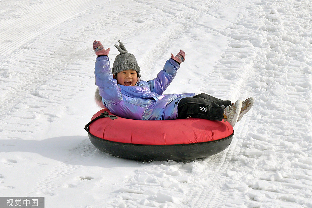 2023年1月10日,山东烟台一滑雪公园里,小朋友在体验雪圈滑雪.