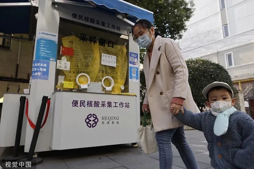 2022年12月13日，上海，市民带着孩子路过一个常态化核酸亭。人民视觉  资料图