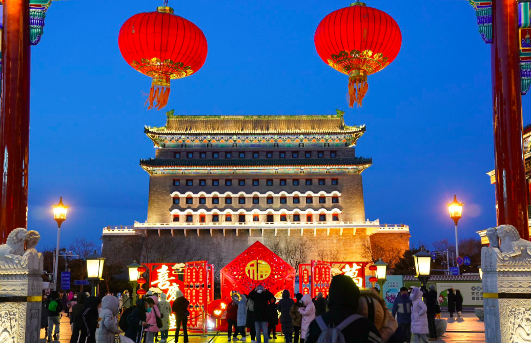 "入夜后,前门大街一派火树银花的绚烂景象,游客频频举起手机拍照,一边