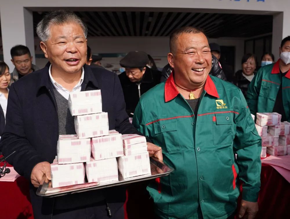 1月10日,种粮大户凌继河(左一)正在给农民发年终奖.