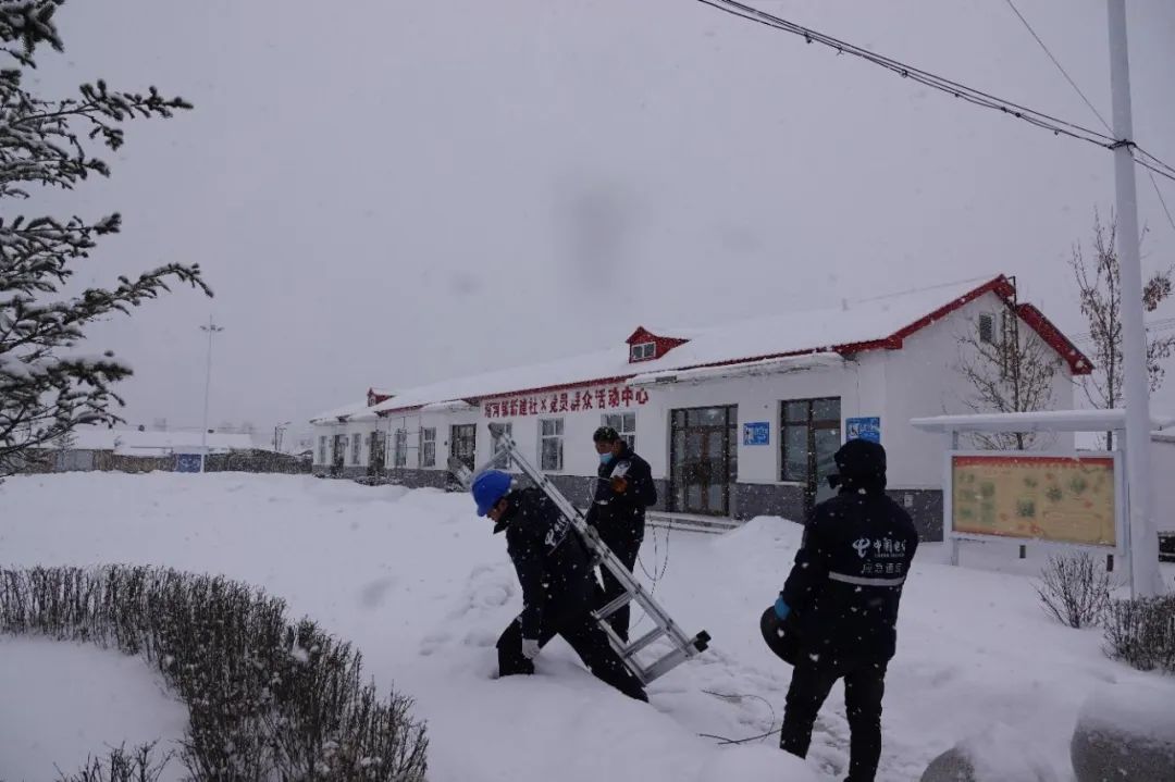 塔河电信工作人员在齐膝深的雪地，肩扛设备艰难行走。