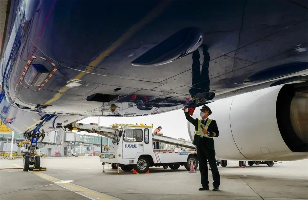 1月6日,重庆江北国际机场的停机坪上,机长菅士博对客机进行起飞前的绕