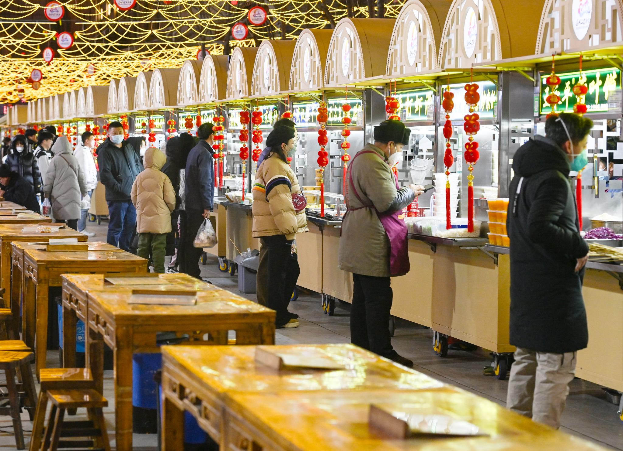 游客在延安二道街夜市选购小吃(1月13日摄).
