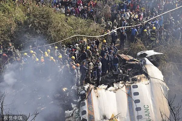 当地时间2023年1月15日，尼泊尔救援人员和平民聚集在坠毁在尼泊尔博卡拉的客机残骸周围。图/视觉中国