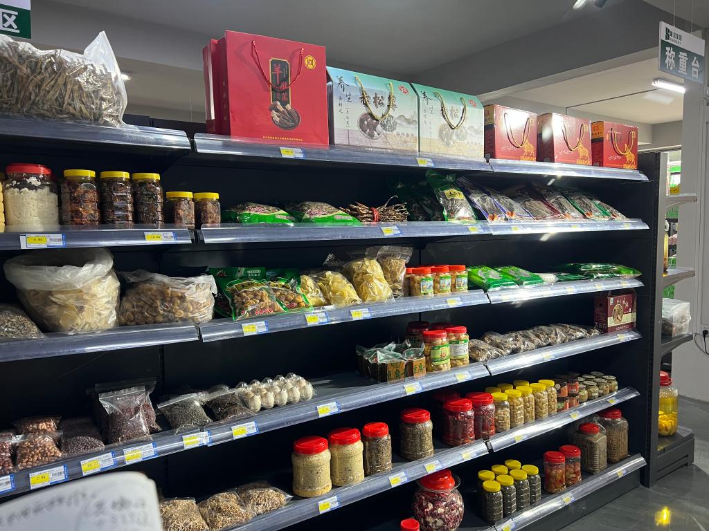 图为务川县泥高镇"乡村振兴服务站"超市里销售当地农特产品的货架.