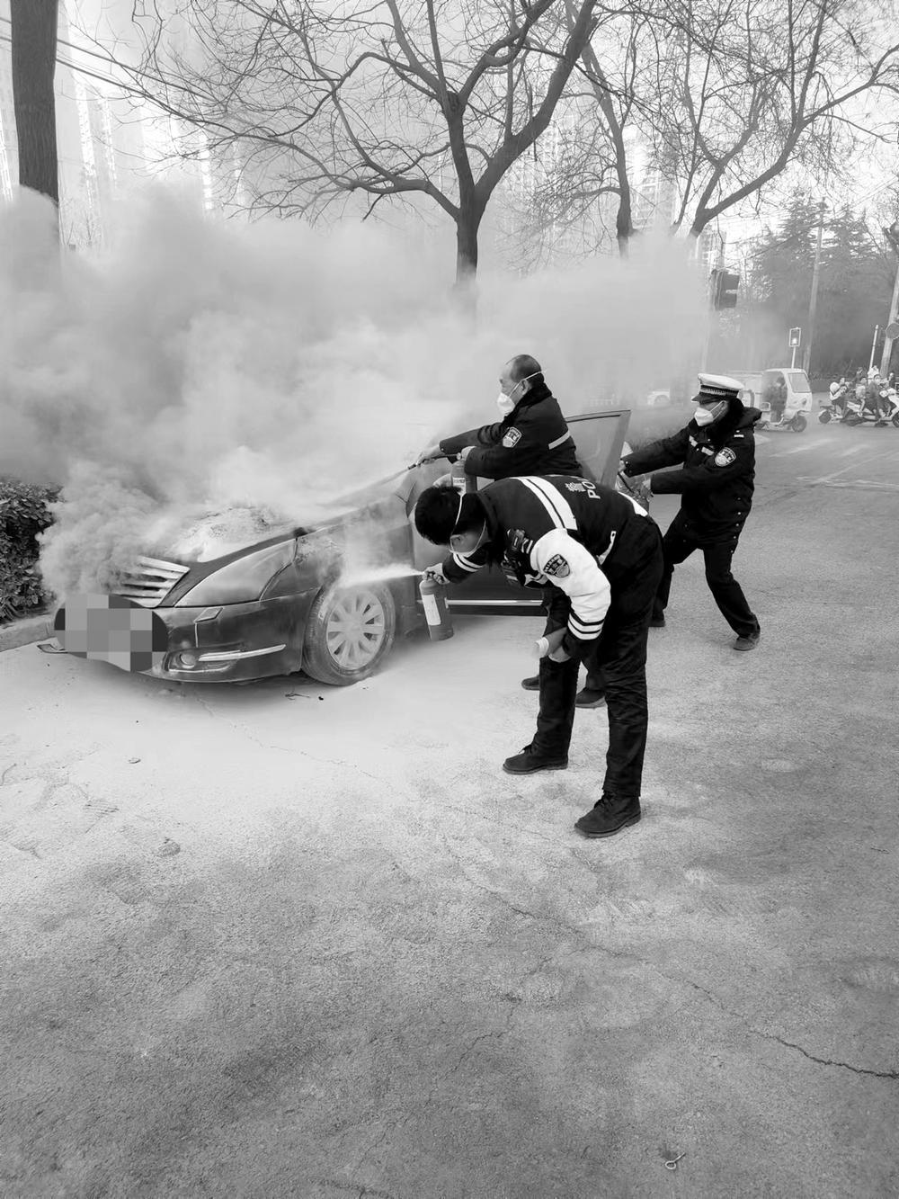 图为交警用灭火器为自燃车辆灭火.  (裕华交警供图)