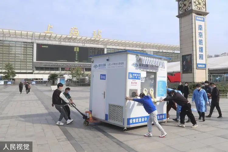 上海工作人员正将核酸检测亭推离。/人民视觉