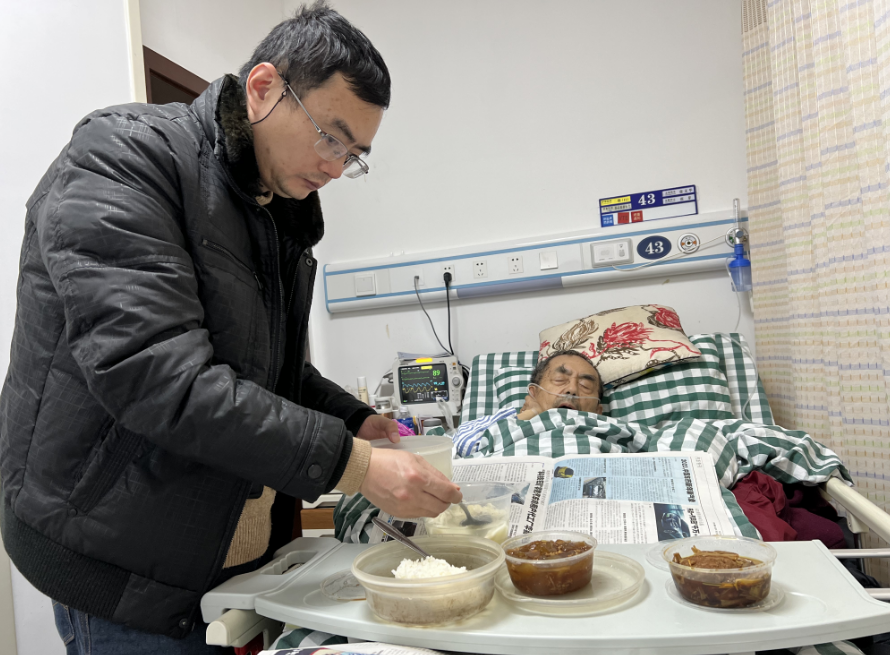 ▲金晓宇在病房里照顾父亲