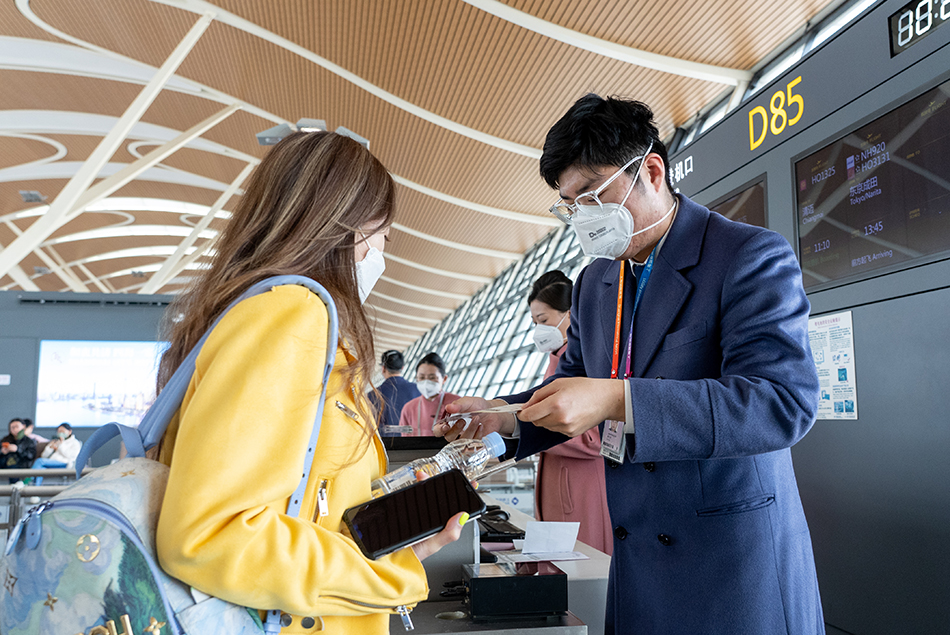 旅客在登机口扫描登机牌准备登机.受访者供图
