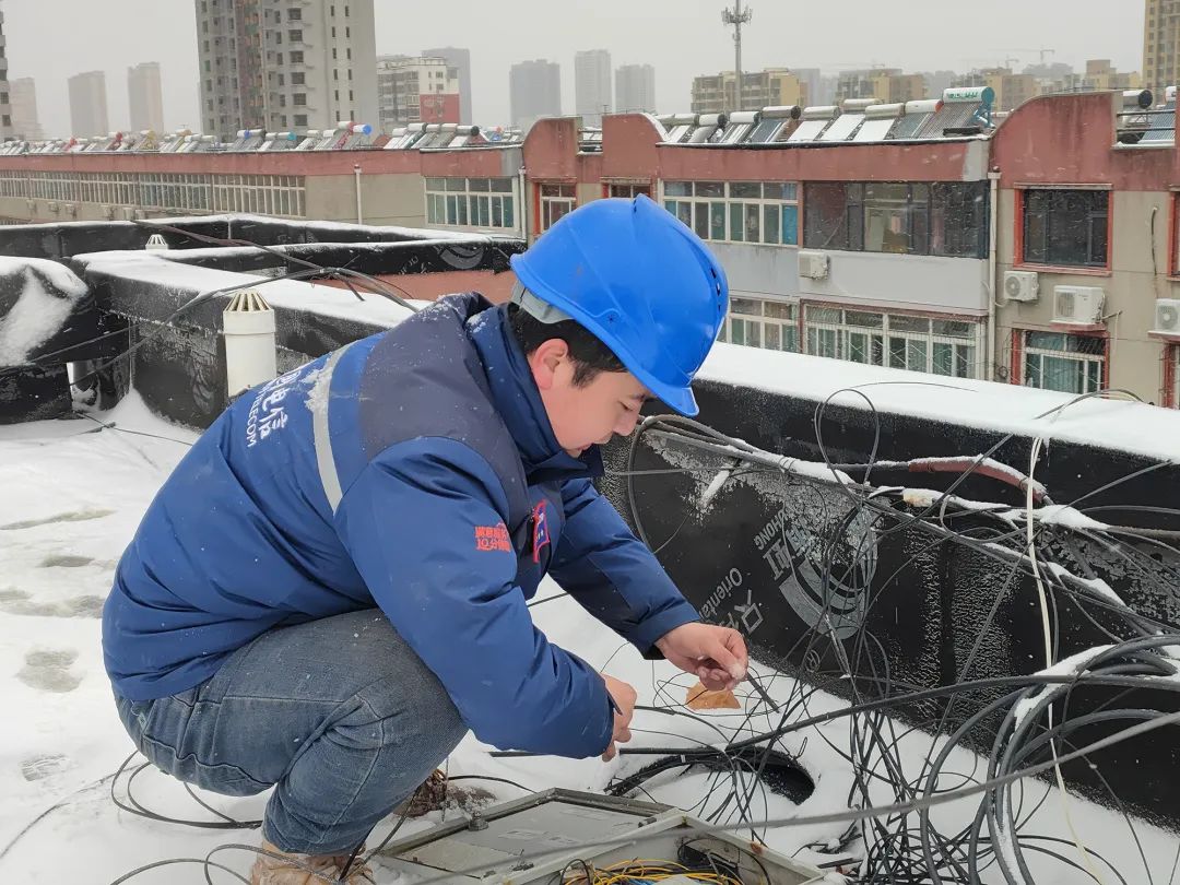 图为中国电信邢台分公司智家工程师顶风冒雪为用户熔纤装机调通宽带