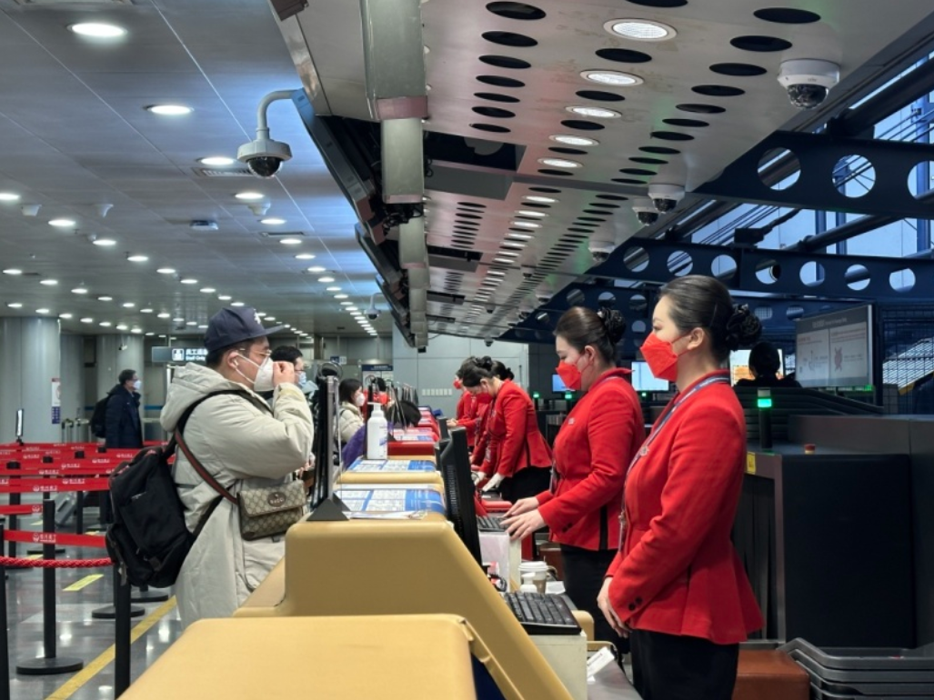 四川航空值机柜台工作人员服务旅客办理业务/记者拍摄