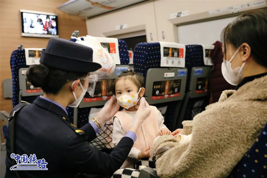 列车长方婷为可爱的小旅客佩戴好口罩