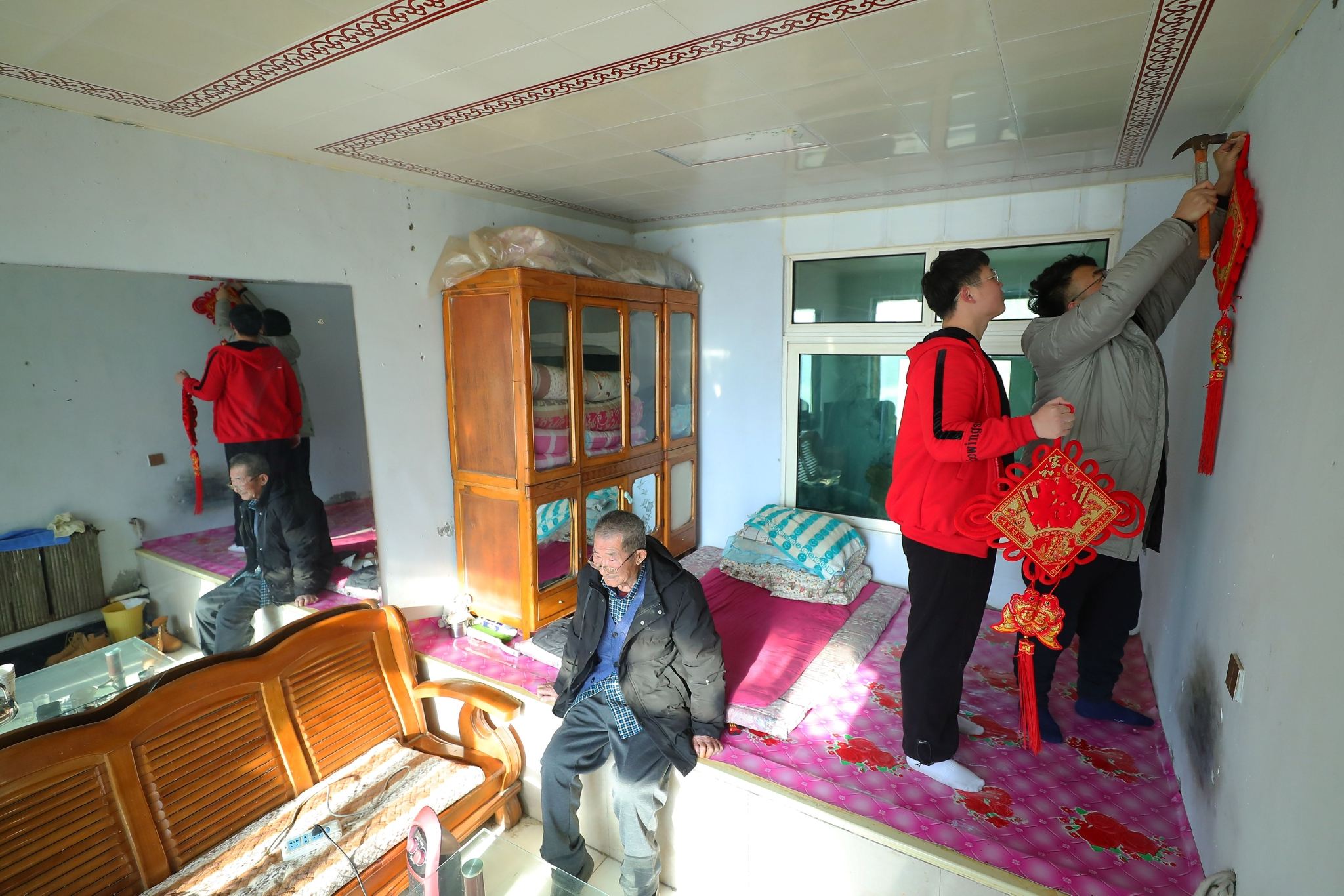 1月20日,沈阳工学院老师和李天骐(中)一起挂灯笼.