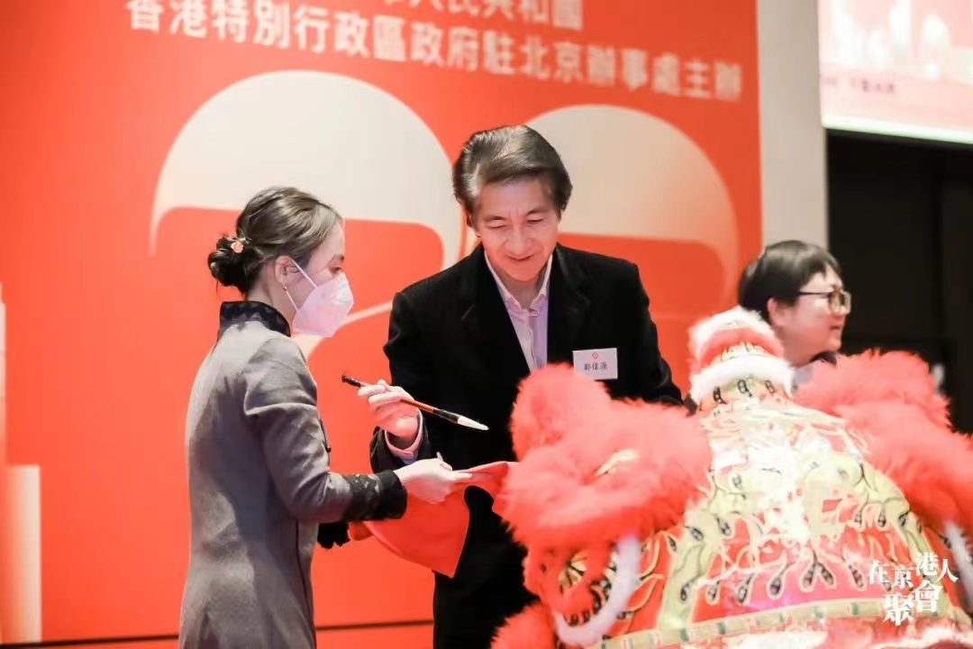 郑伟源在“2023在京港人聚会”上为舞狮点睛