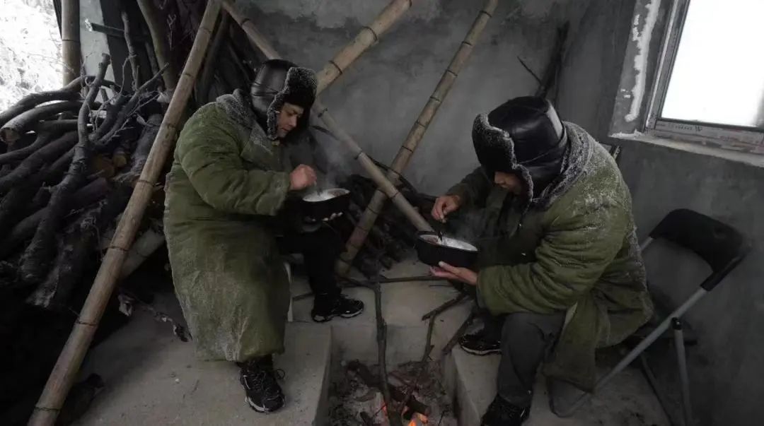 融冰间隙，尹斌和刘昌武在110千伏西公线03号观冰点临时哨所食用自热米饭等方便食品。
