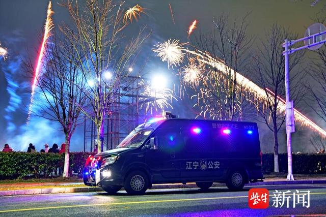 图为在烟花集中燃放点,警车闪烁的警灯与市民燃放的烟花交相辉映