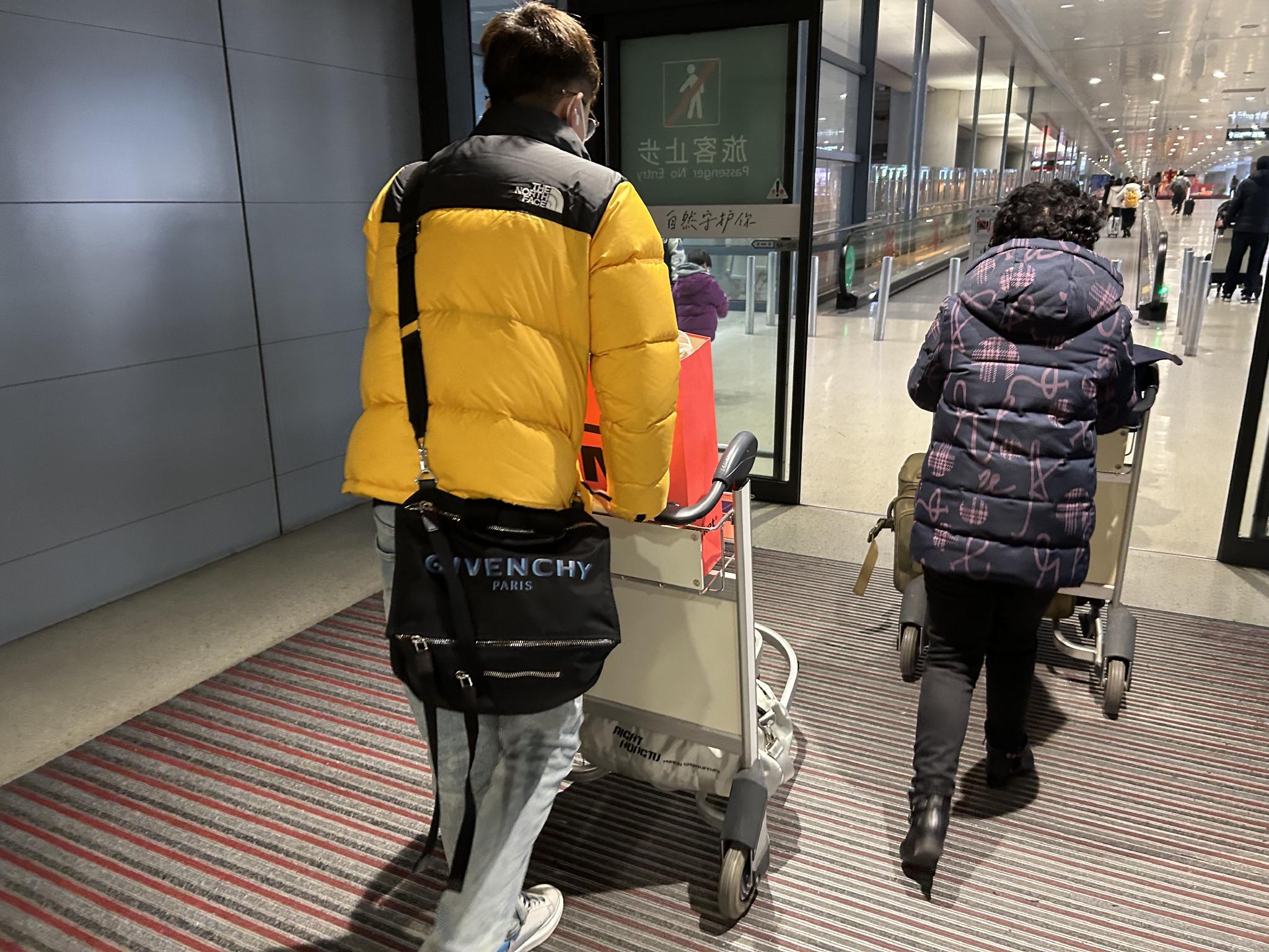 1月26日中午，何先生走出上海虹桥机场T2航站楼。  澎湃新闻记者 李佳蔚 图