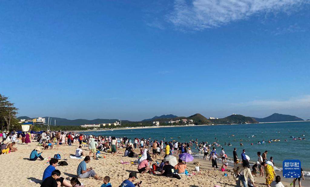 1月24日，游客们在三亚大东海游玩。新华社记者 郭良川 摄