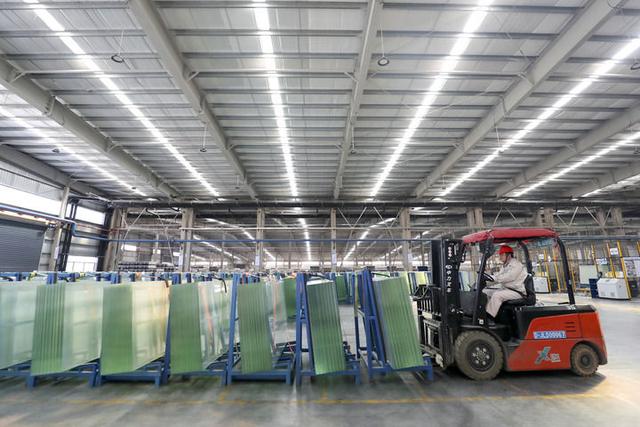 1月28日，湖南资兴经济开发区一家公司的工人在光伏组件高透基板材料生产车间忙碌。新华社发（李科 摄）
